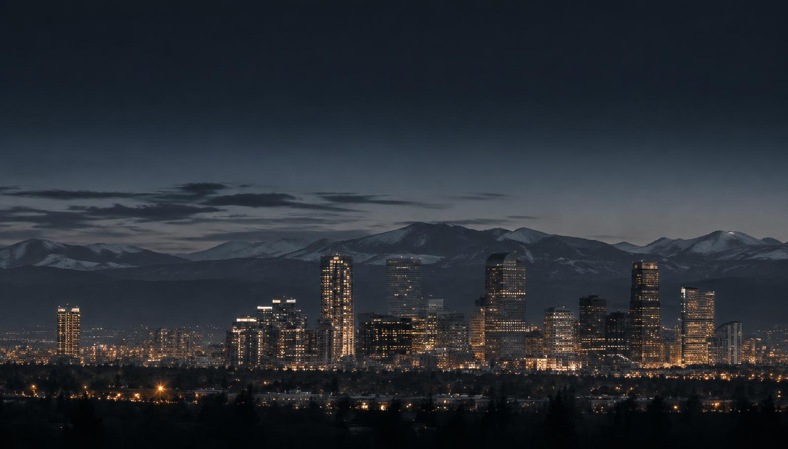 Denver skyline at dusk with the Rocky Mountains